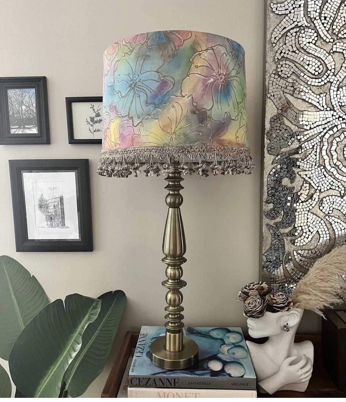 A lamp with a colorful shade on top of a table.