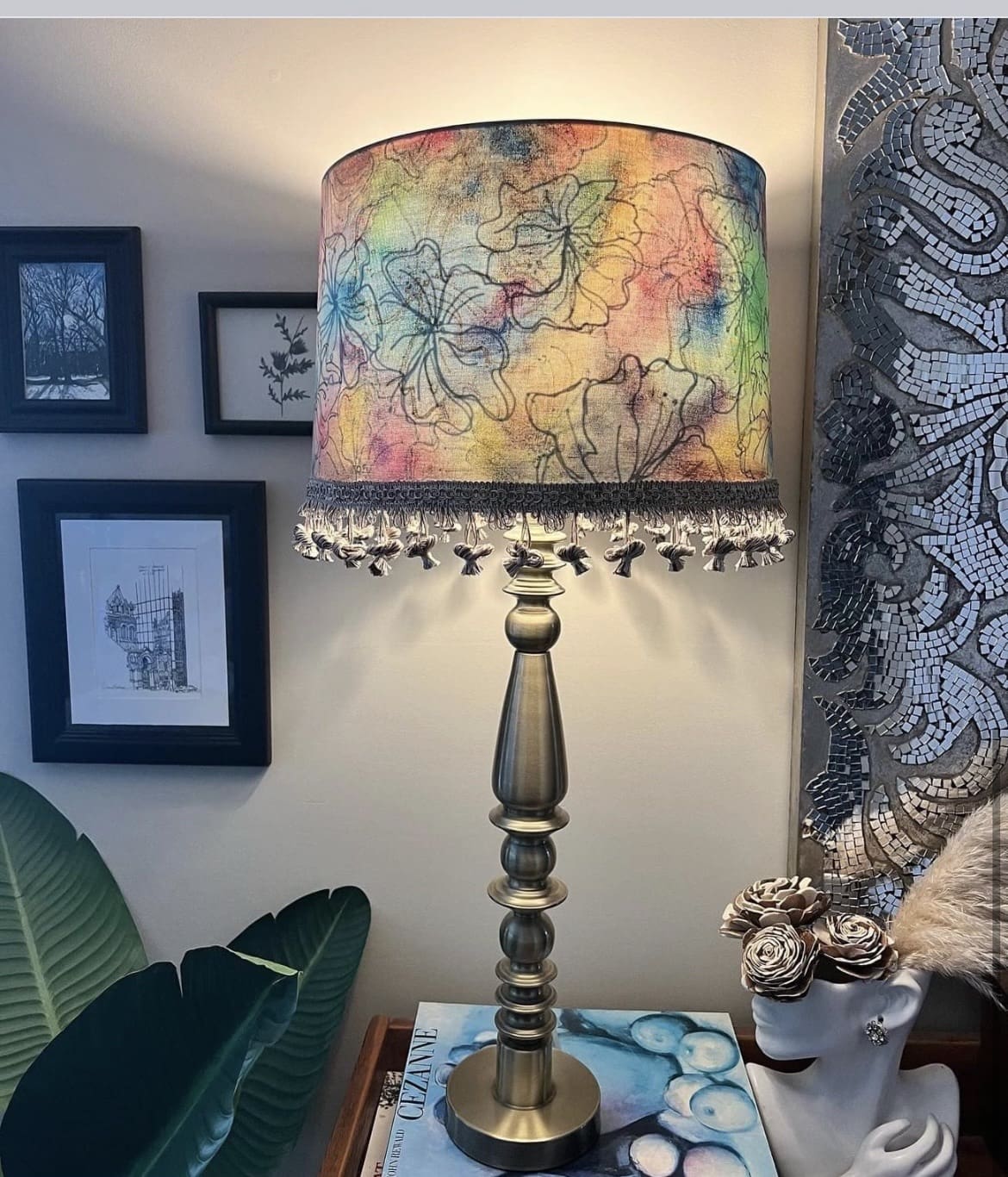 A lamp with a colorful shade on top of it.