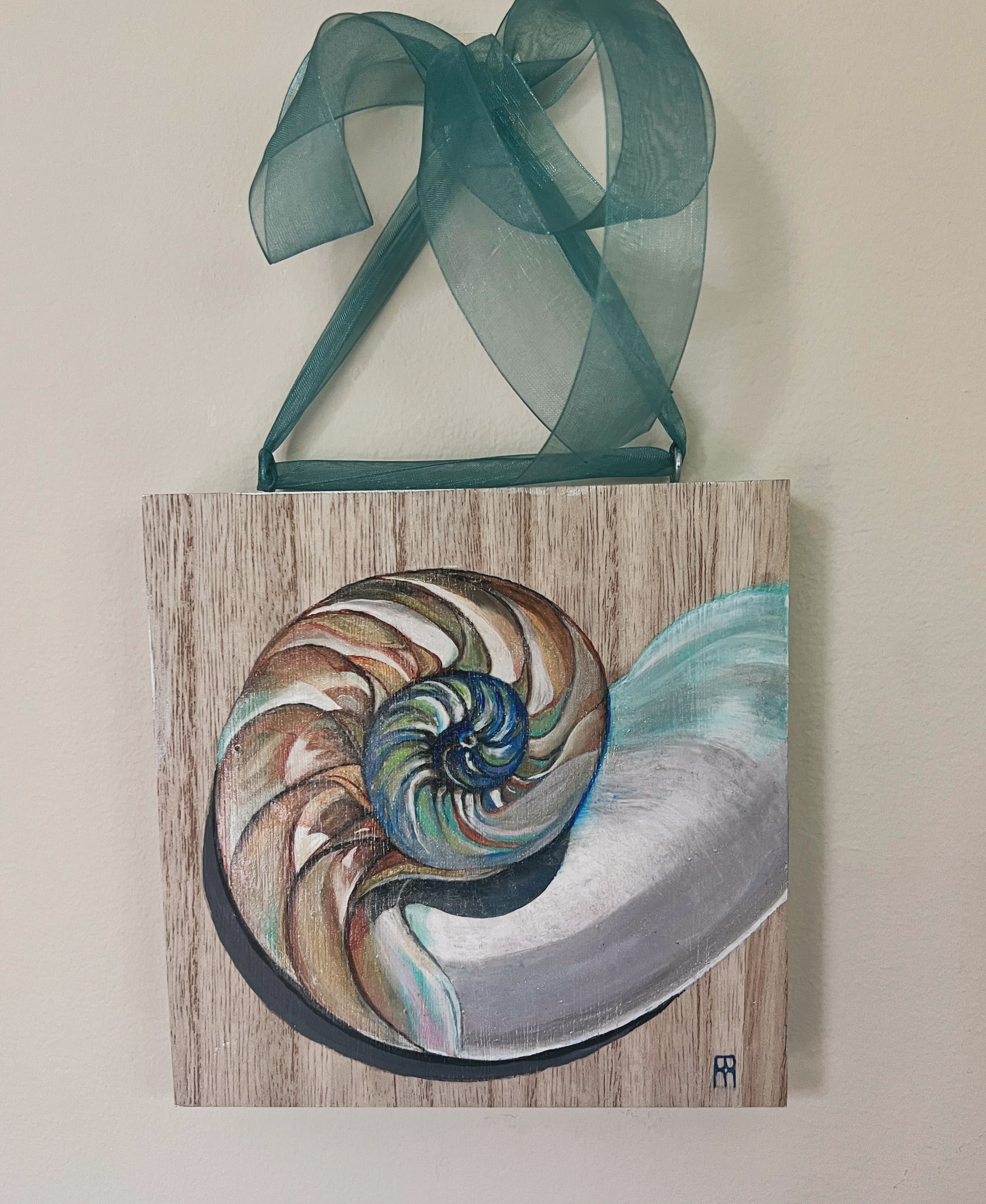 A painting of an ammonite shell hanging on the wall.